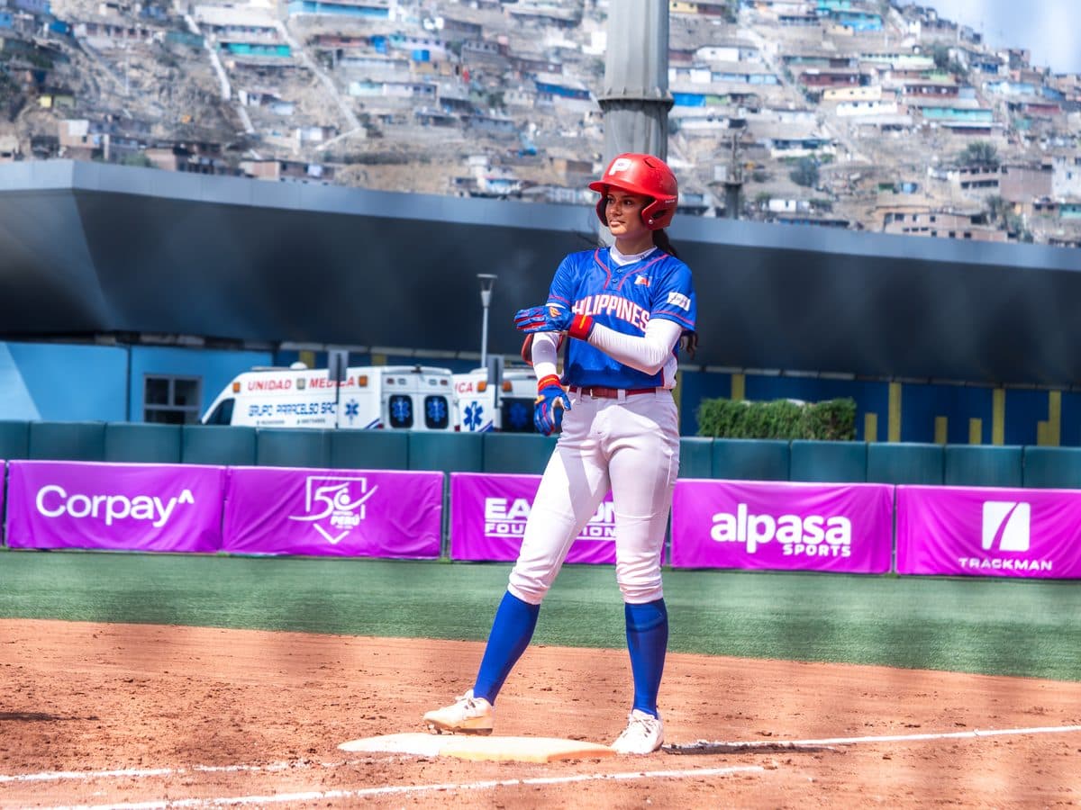 Jugadora de Filipinas en base ante Puerto Rico, con los cerros de Villa María del Triunfo al fondo. Foto: Billie Saldarreaga / Pelotón B.