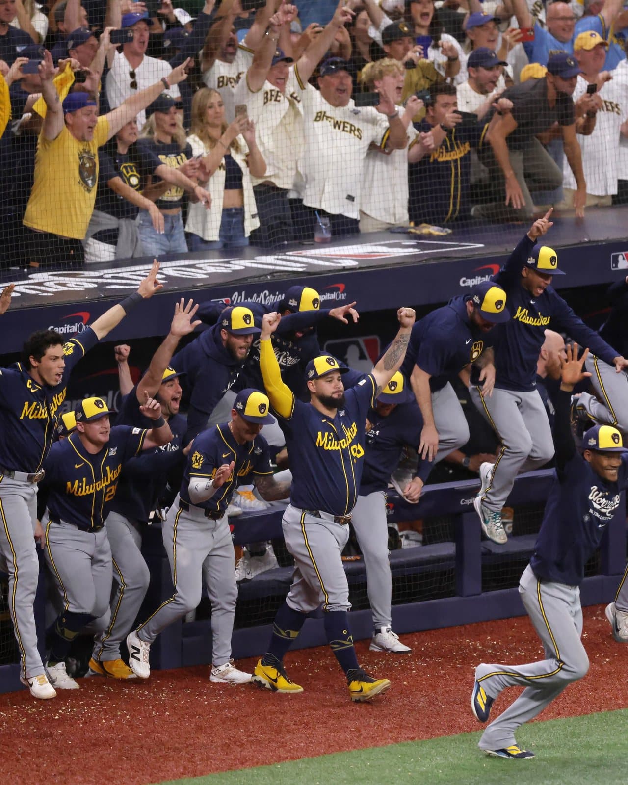 El dugout de Milwaukee estalla mientras los fanáticos celebran detrás. Foto: MLB.com.