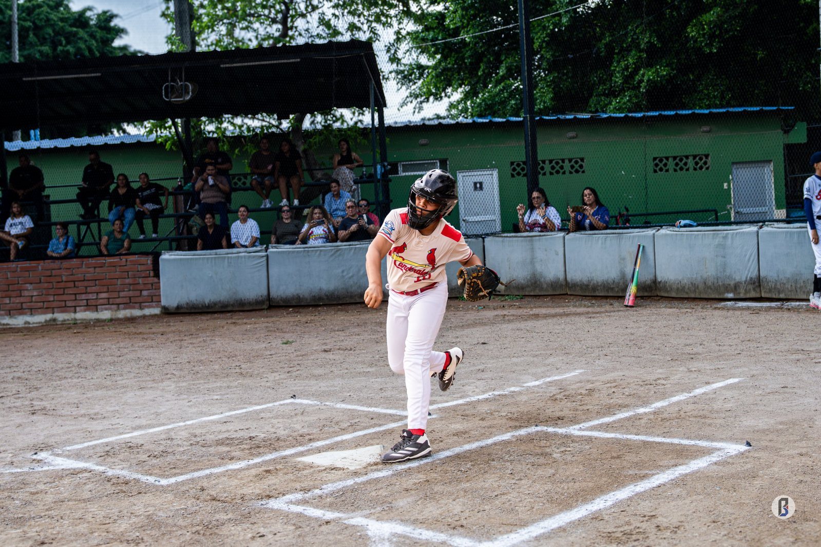 Jhoiver Oropeza (Cardenales) sale disparado desde home plate ante la mirada del público en las gradas. © Pelotón B.