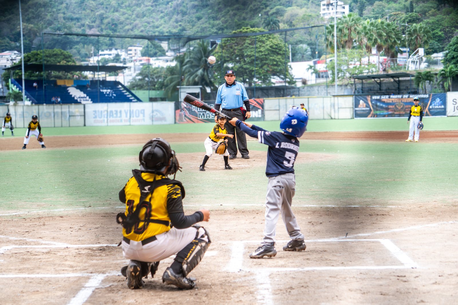 Un pelotero conecta en Miraflores, con el árbitro atento y los cerros de la ciudad al fondo. Foto: Billie Saldarreaga / Pelotón B.