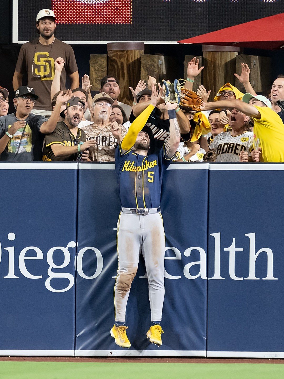 Garrett Mitchell (#5) atrapa contra el muro el batazo de Manny Machado en la octava entrada. Foto: Milwaukee Brewers.