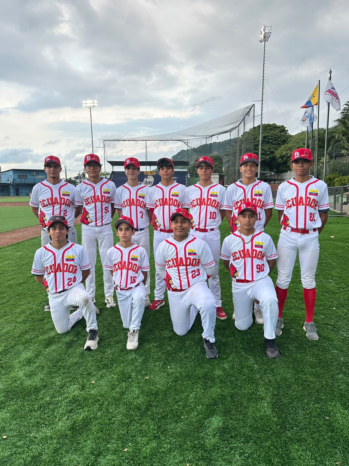 Los once jugadores de Cardenales con el uniforme local blanco en el campo de béisbol antes de su viaje a Colombia. Foto: Club Cardenales.